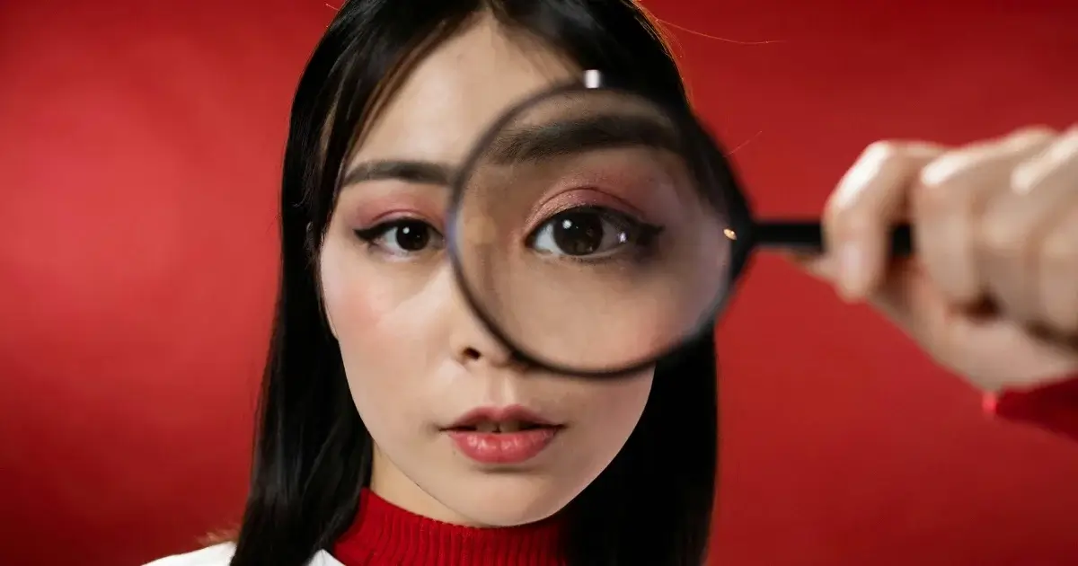 A girl looking through a magnifying glass.