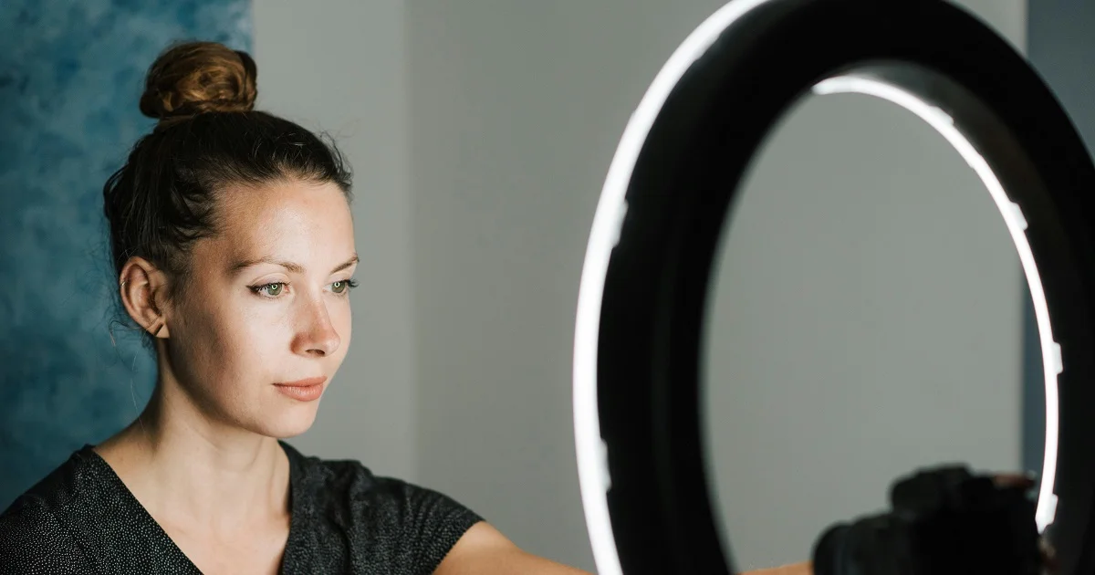 Woman taking a selfie for the dating apps with a professional ring light.